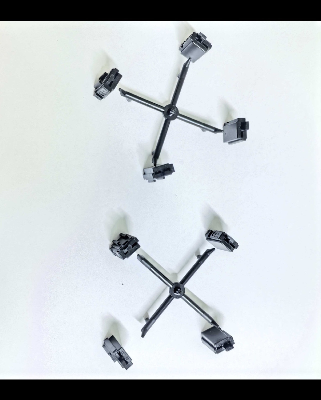 Small black molded samples attached to runner systems